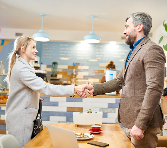 Une étudiante en TP NTC serre la main d’un client.